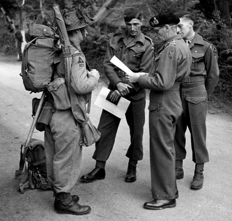 General Montgomery reads the 'Packing List' for a 2 RUR Rifleman preparing for the D-Day landing, Operation OVERLORD. Rfn McCracken stands before him, wearing and carrying the contents of that list.